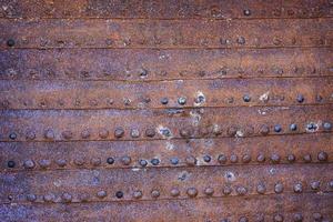 Weathered rusty metal textured background with big old rivets photo