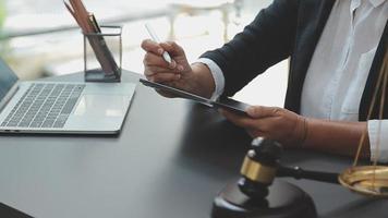 Business and lawyers discussing contract papers with brass scale on desk in office. Law, legal services, advice, justice and law concept picture with film grain effect video