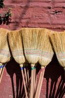 Set of yellow straw broom in bazaar