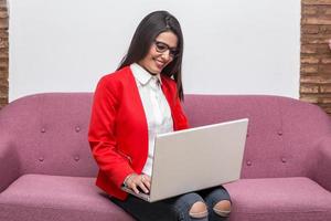 Woman sitting on couch at table and working on notebook photo