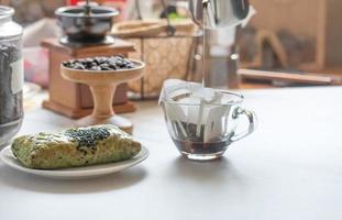 Drip coffee in a bag, drip in a clear coffee mug. photo