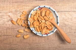 Peanuts in a cup on wooden background photo