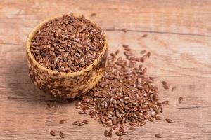 flax seeds in a wooden bowl on a wooden background, top view photo