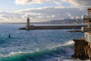 Port in the evening, beacon and the blue sea, lighthouse in the harbor in summer, seascape, Nice, France. photo