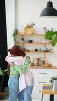 Two women hug each other in kitchen video