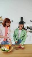 Young women in kitchen slicing fruit video