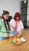 Young women in kitchen slicing fruit video
