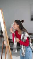 Woman applies makeup before a large mirror video