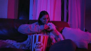 kvinna reagerar till film medan sittande på soffa med popcorn video