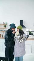 Two women in kitchen bundled up for the cold video