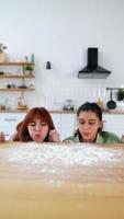 las mujeres jóvenes juegan con harina en la mesa video