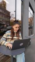 vrouw gezeten buiten Bij koffie winkel met laptop video
