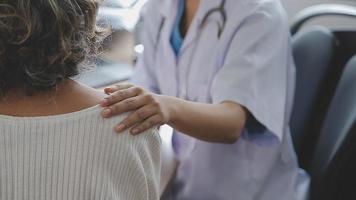 un médecin ou un kinésithérapeute examine les douleurs à l'épaule et donne des conseils au sein d'un centre de rééducation. video