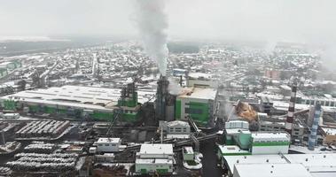 flight near pipes with white smoke of woodworking enterprise plant sawmill. Air pollution concept on industrial landscape in winter with snow video