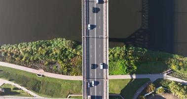 aerial view on heavy traffic on a bridge with a wide multi-lane road across a wide river video