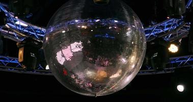 Nachtdisco mit neonblauem violettem Rotlicht, Disco-Spiegelkugel und hellem Flutlicht mit runder Metallrahmen-Leuchtkonstruktion video