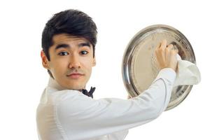 Portrait of a handsome young waiter that looks into the camera and side tray cloth close-up photo