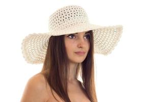 Close Up retrato de joven hermosa morena chica en sombrero de paja con ala ancha posando aislado sobre fondo blanco. foto