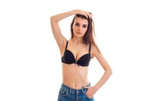 young beautiful girl with natural big breasts in a black bra looks into the camera and holds hand hair photo
