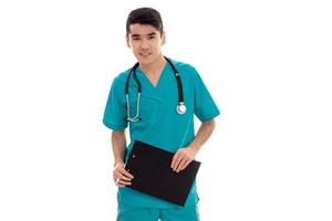 a young doctor with stethoscope looks at the camera and holding a Tablet photo