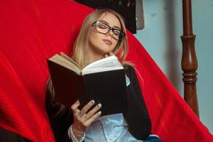 chica en silla roja con libro foto