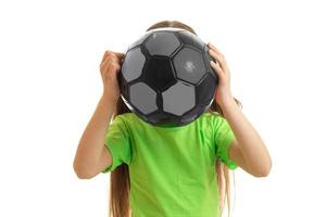 Funny young girl in green shirt with ball in hands photo