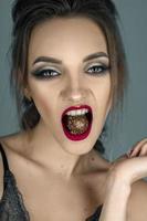 gorgeous girl with red lips eats chocolate candy and looking at the camera photo