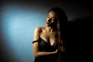 Gorgeous lady with curly hairstyle in dark studio photo