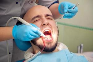 close up photo of handsome guy treats caries teeth in the dental office