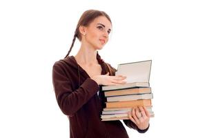 girl with pigtails stands sideways looks away and holds books isolated on white background photo