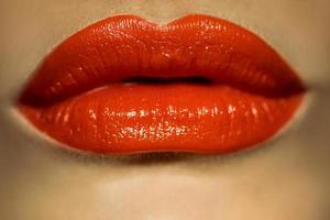 imagen macro de labios femeninos con lápiz labial rojo foto