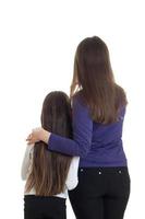 Vertical of adult mother hugs her little daughter in studio photo