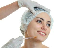 Portrait of a charming young girl in a special cap for hair which the doctor inserts the injection and she smiles close-up photo