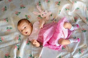 Adorable newborn girl in pink dress photo