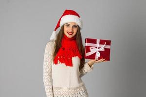 chica con sombrero de santa con regalo foto