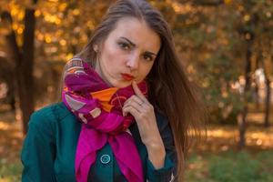 Portrait of a young girl with  pensive pink scarf that stands on the street photo