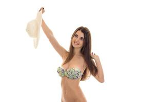 cheerful slim young lady with big natural breast posing in swimsuit with straw hat in hands isolated on white background photo