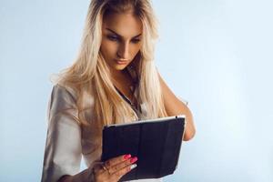 Caucasian adult nurse with blonde hair looking at tablet photo