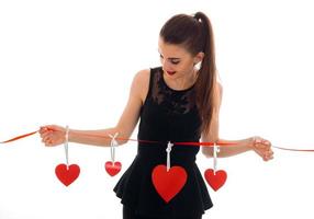 Lovely young brunette girl posing with red heart isolated on white background. Saint Valentines Day concept. Love concept. photo