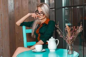 Horizontal portrait of young beautiful business woman in a cafe with cup of tea photo