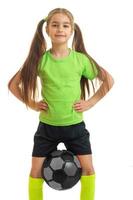 retrato vertical deportes niña que sostiene la pelota entre las piernas foto