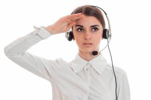 retrato de una joven y hermosa chica de la oficina de llamadas con camisa blanca y auriculares aislados en el fondo del estudio foto