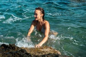 young girl in the clear blue sea photo