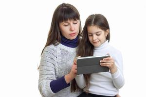 madre con su hija usando una tableta móvil foto