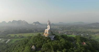 uma vista aérea do grande buda na montanha se destaca no templo nong hoi em ratchaburi perto de bangkok, tailândia video