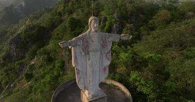 An aerial view of Christ the Redeemer on the mountain stands prominently at Hup Pha Sawan in Ratchaburi near the Bangkok, Thailand video