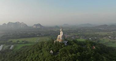 uma vista aérea do grande buda na montanha se destaca no templo nong hoi em ratchaburi perto de bangkok, tailândia video