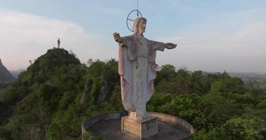 An aerial view of Christ the Redeemer on the mountain stands prominently at Hup Pha Sawan in Ratchaburi near the Bangkok, Thailand video