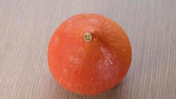 Orange pumpkin rotating on wooden background. Healthy vegetable vegetarian food. video
