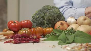 donna mani preparazione verdure nel moderno casa cucina, cucinando pasto su tavolo, taglio zucchine. vegano vegetariano ingredienti, mediterraneo cibo salutare stile di vita video